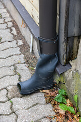 Stiefel als Ende des Fallrohres einer Regenrinne
