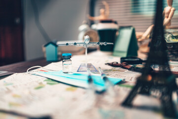 Vaccine, syringe and mask on map. Important equipment before traveling during COVID concept.