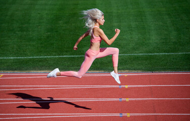 Obraz premium fitness competition. trainer or coach training. marathon. energetic and sporty. fitness woman in sportswear. athletic lady run on stadium running track. female athlete ready for sprint sport workout