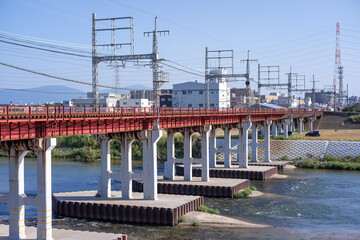 橋脚が帯状鋼板とコンクリートで強固に補強された大和川に架かる鉄道橋