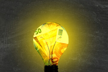 Eine Glühbirne, Euro Geldscheine und die Energiekosten