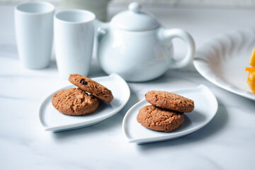 Cookies in a white plate, teapot, afternoon snack.