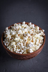 Salted popcorn in a bowl with 3D glasses on a table on a gray background. Top view