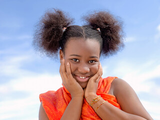 Pretty girl with pigtails smiling, Afro hairstyle, eleven years old, blue sky, white clouds, photo 