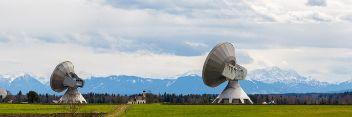 Bavarian landscape with two satellite dishes (Raisting radome). In the distance a church and...
