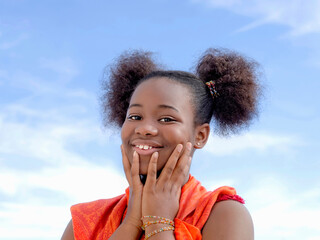 Pretty girl with pigtails smiling, Afro hairstyle, eleven years old, blue sky, white clouds, photo 