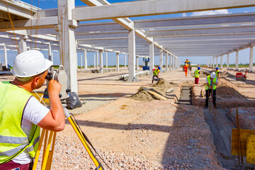 Civil engineer, geodesist is working with total station on a building site