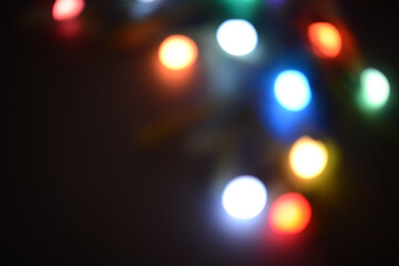 Christmas lights on a dark background, blurred lights of Christmas garlands