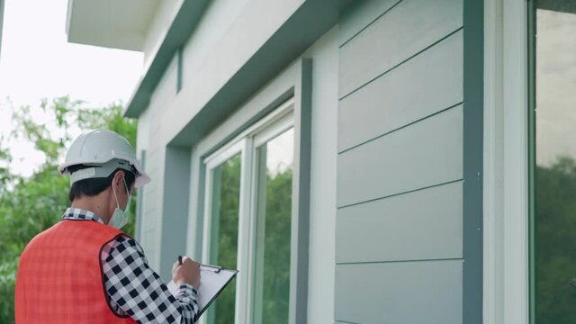 improvement by engineer. On site engineers are writing down the details of the home inspection on paper. The contractor takes details of the areas that need renovate.
