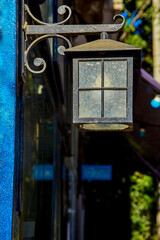 city lantern on the wall of a house on a city street on a sunny day
