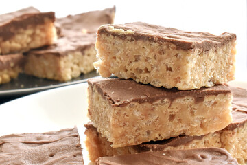 Chocolate caramel rice crispy treats on a white plate.  Copy space is on the right side. 