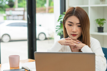 Portrait Of Attractive Asian Businesswoman Working On Laptop for marketing plan