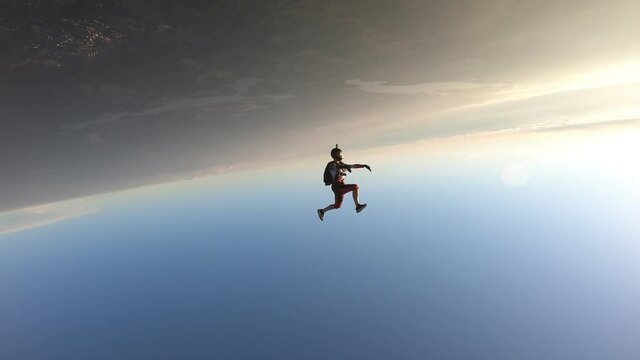 Freefly skydiving. Headdown jump. A happy girl is having fun in the sky. Sunset time.