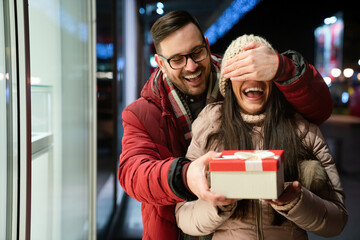 Beautiful couple in love is celebrating with gift outdoor. Enjoying time together in Valentine's