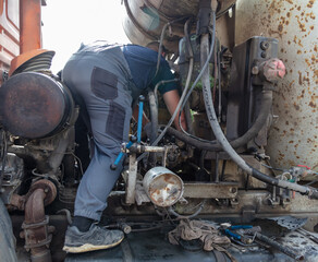 Worker repairing an engine in a truck