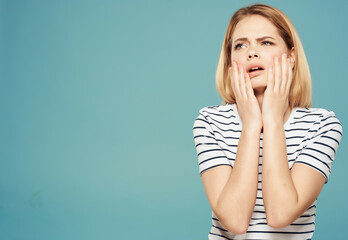 woman holding her head emotions displeasure upset blue background