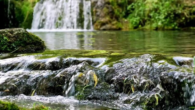 Nature background. Slow shutter speed, motion photography. Waterfall landscape. Beautiful hidden waterfall in rainforest. Water reflection. Tropical scenery. Horizontal layout. River landscape.