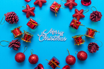 Inscription Merry Christmas on a blue paper and decorations. Flat lay, top view.