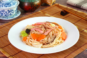 Vegetarian Hong Kong Noodle.  Stir fried Hong Kong noodle with mushroom, carrots, green vegetables and veggie sausage. Chinese vegetarian noodle for vegetarian festival.