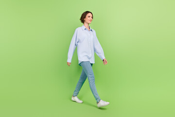 Fototapeta na wymiar Full length profile side photo of young woman happy positive smile go walk step isolated over green color background