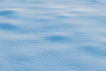 Snowy background, snowy surface with a clearly expressed texture of snow in the morning sun