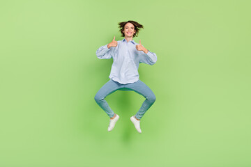Fototapeta na wymiar Full length photo of happy cheerful woman jump up make thumbs up advert isolated on green color background