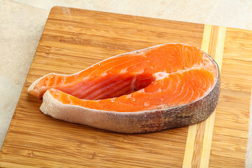 Raw salmon steak over board
