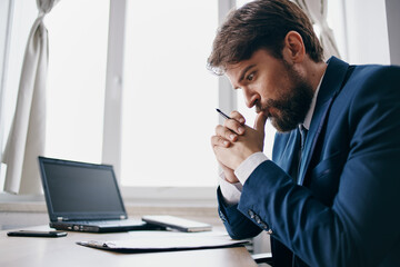 bearded man sitting at a desk in front of a laptop finance technologies