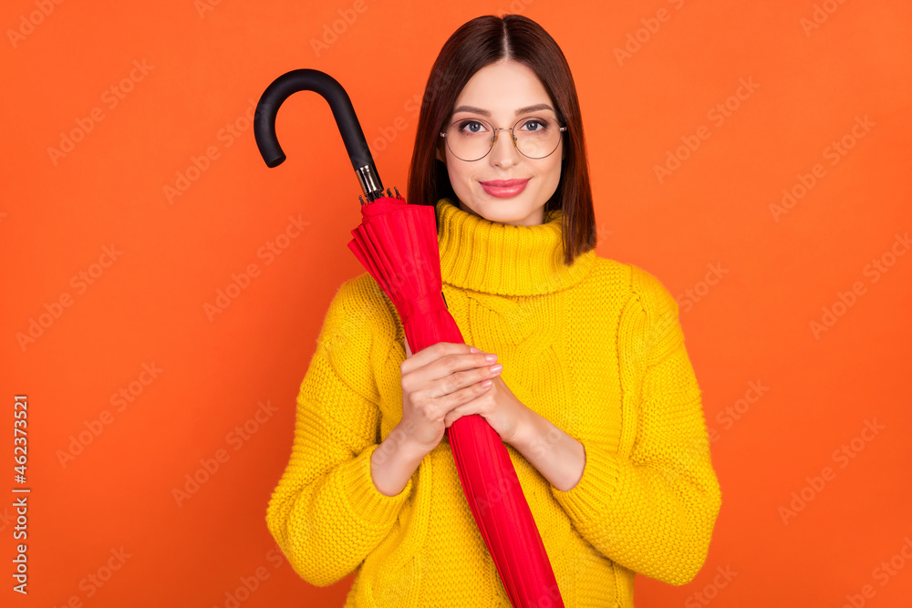 Sticker Photo of young woman happy positive smile hold umbrella weather wear glasses isolated over orange color background