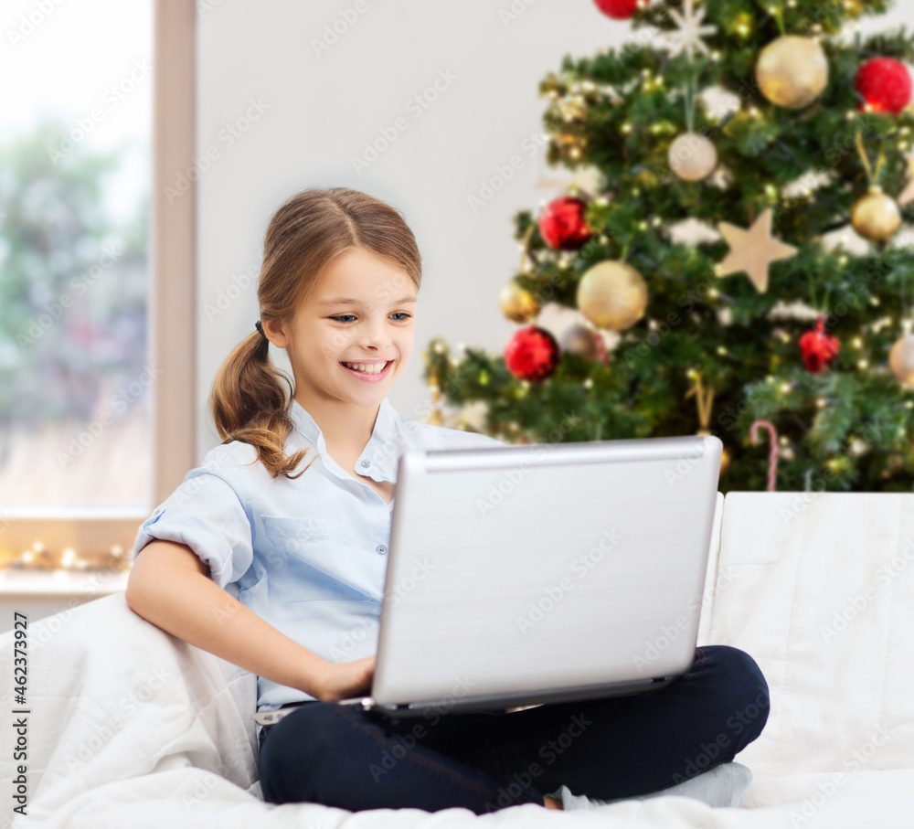 Sticker winter holidays, technology and children concept - little student girl with laptop computer at home 