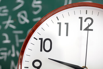 Alarm clock time concept in front of blackboard