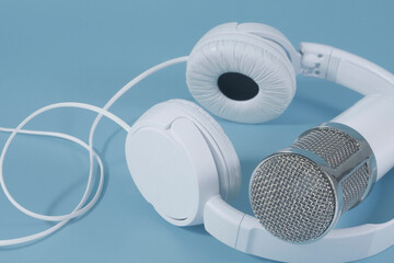 Headphones and microphone for sound recording on a blue background with space title.