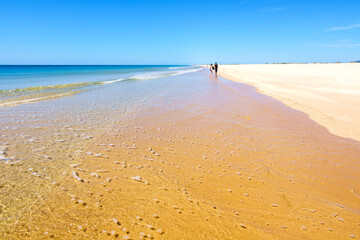 Couple walking on the beach at Ilha de Tavira, Portugal