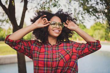 Photo portrait woman walking in city wearing stylish glasses checkered shirt smiling happy in summer