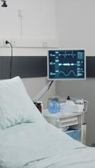Nobody in hospital ward for resuscitation and healthcare. Empty emergency room with medical equipment, IV drip bag and heart rate monitor for intensive care and assistance for recovery
