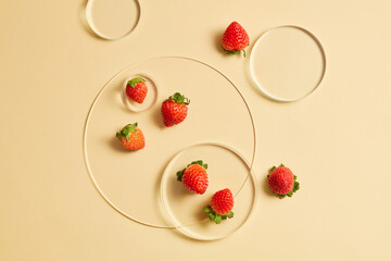 Strawberry on circle glass platform on beige background.