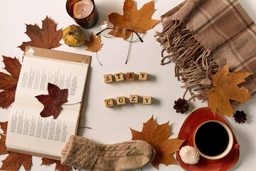 still life, season and objects concept - stay cozy words made of wooden toy blocks with letters or...