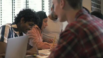 Young beautiful muslim woman in hijab student studying with multiracial friends students. Happy young people working, doing project, sturtup in the office