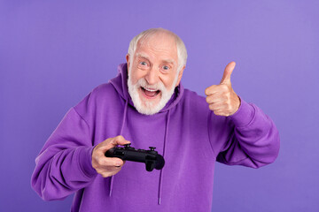 Portrait of elderly retired trendy pensioner cheery man playing showing thumbup isolated over...
