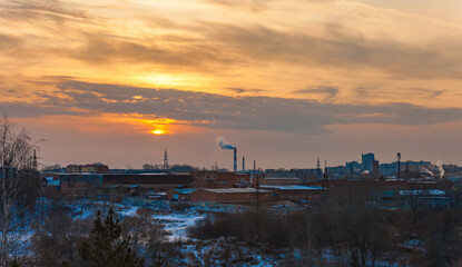 Fototapeta premium Sunset over the industrial area of the city in winter