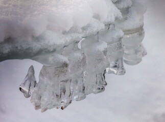 Icicles and frost on a snow-covered frozen river