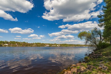 River banks against white clouds and blue sky in summer