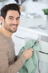man wiping cutlery in the home