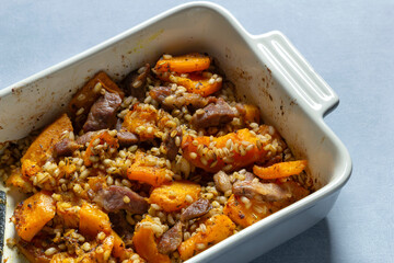 Pumpkin barley meat bake in oven on table. Home food.