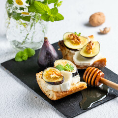 Toasted fresh bruschetta with goat cheese and figs and honey. Copy Space.