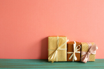 Brown gift boxes on green wooden table. pink wall background