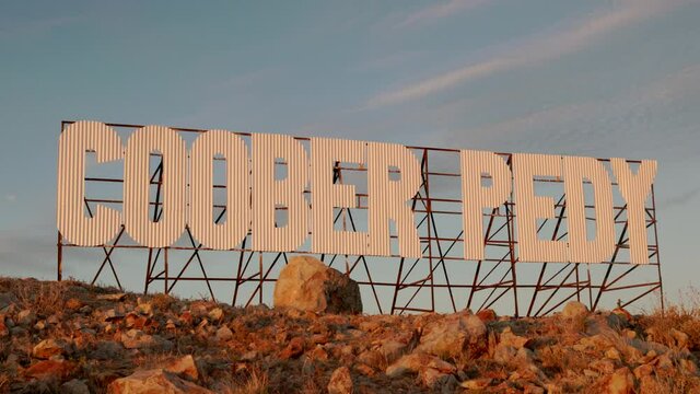 zoom in on a large metal sign with the words coober pedy on a hill at coober pedy in outback south australia