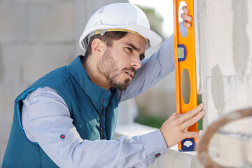 handsome young laborer with level tool