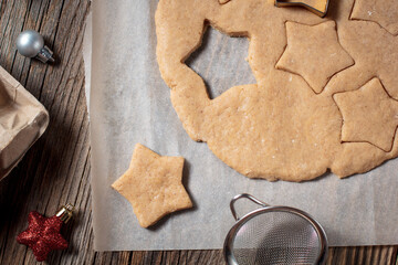 Baking homemade Christmas gingerbread cookies. top view of holiday background with dough spices and fir tree.