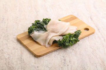 Raw squid over wooden board